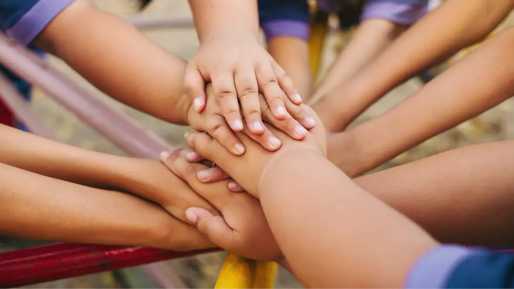 Children's hands in the middle of a circle